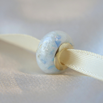 Breastmilk, pearl white shimmer, cornflower blue opal and subtle gold flecks in yellow gold bead