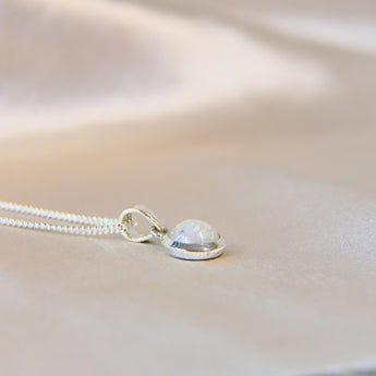 Pearl white shimmer, lightly sprinkled ashes 8mm pendant side view