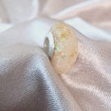 Breastmilk, gold flecks, white crushed opal in faceted bead