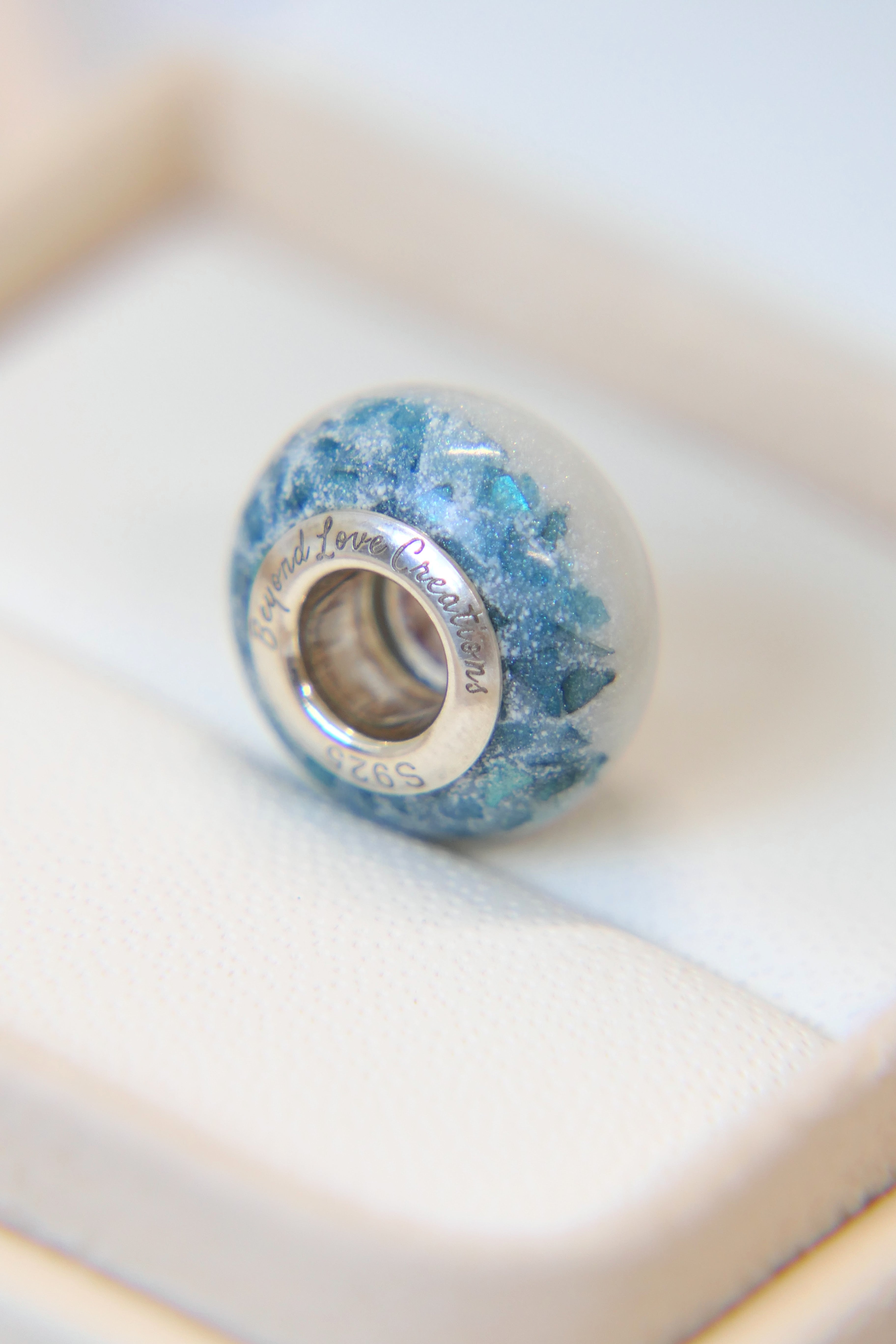 Breastmilk bead with pearl white shimmer and blue flecks 