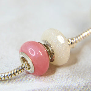 Smooth bead next to faceted bead with crystal shimmer and milk