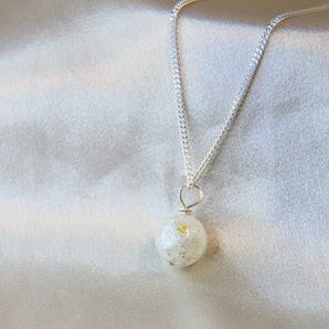 Lightly sprinkled ashes, pearl white shimmer, subtle gold flecks 