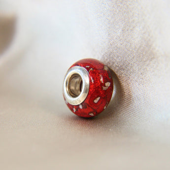 Silver bead, ruby red shimmer and lightly sprinkled ashes 