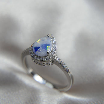 Breastmilk ring pearl white shimmer, cobalt blue opal and opalescent flecks